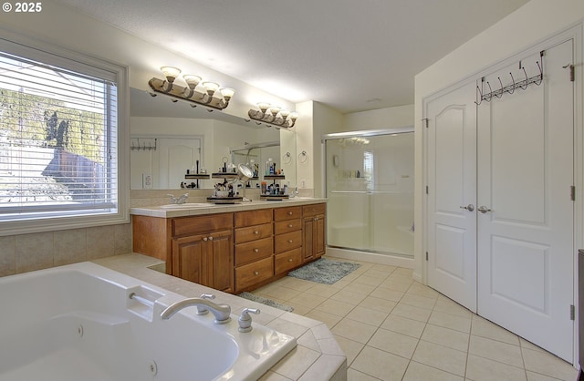 full bathroom with a tub with jets, tile patterned flooring, a wealth of natural light, and a shower stall