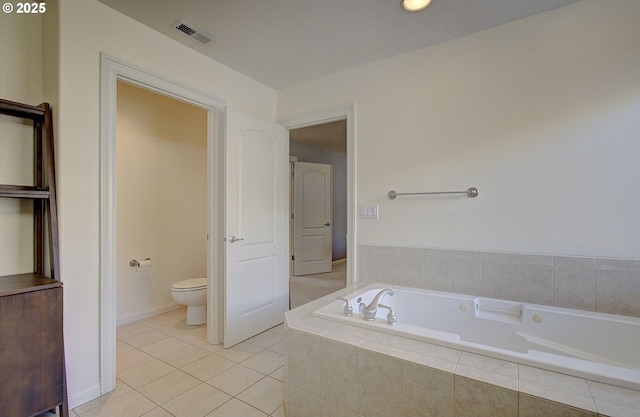 full bathroom featuring toilet, tile patterned flooring, a garden tub, and visible vents