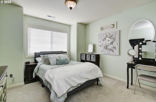 bedroom with visible vents, baseboards, and light carpet