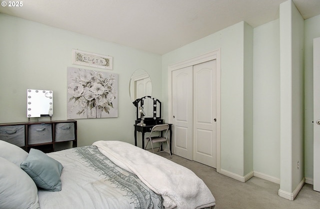 carpeted bedroom with baseboards and a closet