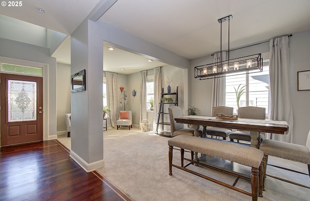 dining area with recessed lighting, baseboards, a notable chandelier, and wood finished floors