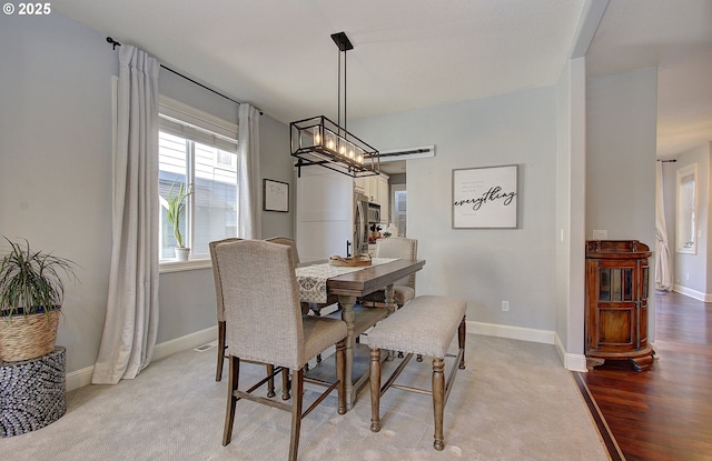 dining room featuring light wood finished floors and baseboards