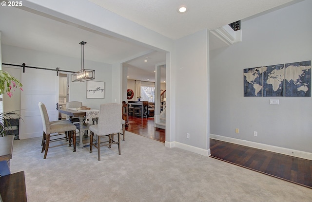 carpeted dining room featuring wood finished floors, visible vents, a barn door, baseboards, and recessed lighting