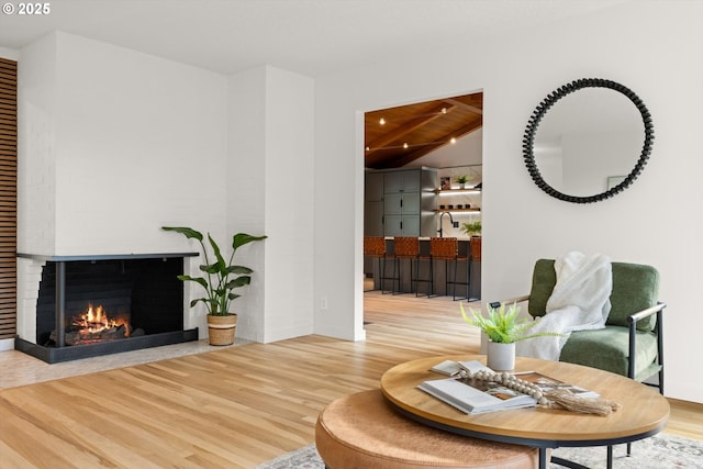 2390 Southshore Blvd, Lake Oswego, OR 97034 - living room featuring wood finished floors, a brick fireplace, and a wooden ceiling with exposed beams