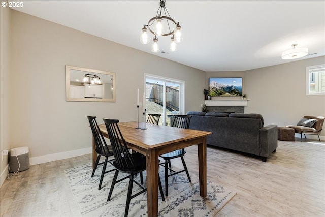 209 W Barbaras Way, Newberg, OR 97132 - dining area featuring light wood-style flooring, a chandelier, and a fireplace