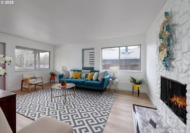 living room with plenty of natural light, a fireplace, and light hardwood / wood-style floors