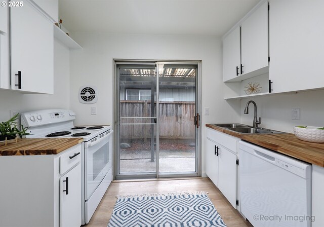 kitchen with sink, wooden counters, white cabinets, white appliances, and light hardwood / wood-style flooring