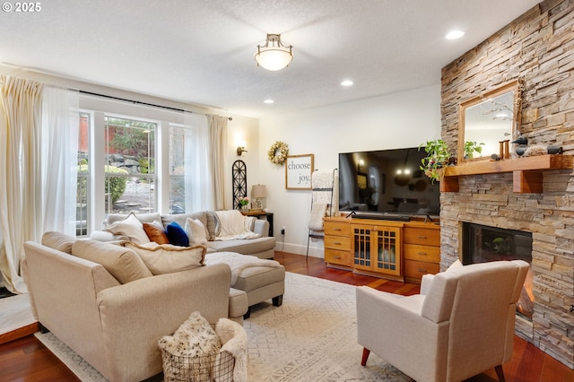 15475 SW Brighton Way, Beaverton, OR 97007 - living room with wood finished floors, a stone fireplace, baseboards, and recessed lighting
