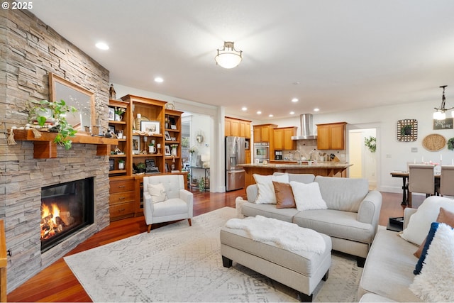 15475 SW Brighton Way, Beaverton, OR 97007 - living room with light wood finished floors, a stone fireplace, and recessed lighting