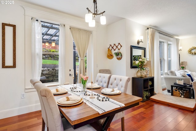15475 SW Brighton Way, Beaverton, OR 97007 - dining space featuring wood finished floors, baseboards, and a chandelier