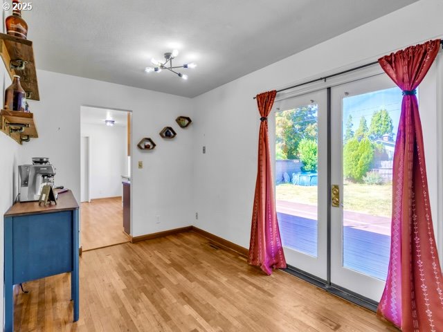 3185 14th Ave, Albany, OR 97322 - unfurnished dining area with light wood-style flooring, a chandelier, and french doors