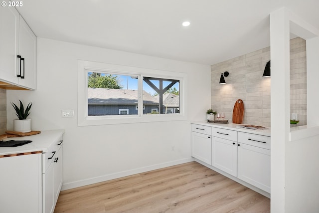 2615 N Gammans Pl, Portland, OR 97217 - kitchen featuring light wood-type flooring, white cabinetry, light countertops, recessed lighting, and decorative backsplash