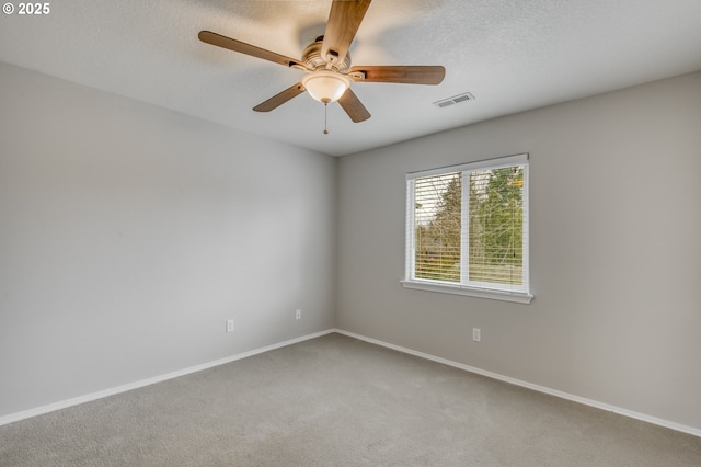 carpeted spare room featuring visible vents, baseboards, a textured ceiling, and a ceiling fan