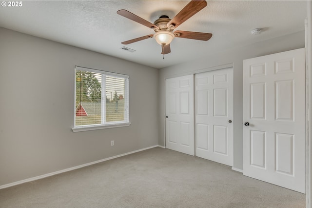 unfurnished bedroom featuring visible vents, baseboards, carpet floors, a closet, and a textured ceiling