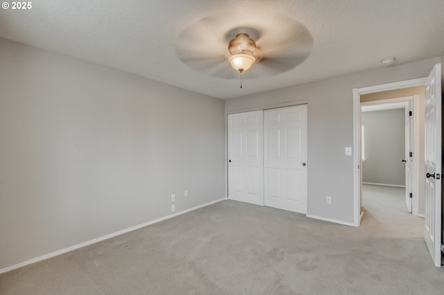 unfurnished bedroom featuring ceiling fan, baseboards, carpet, a closet, and a textured ceiling