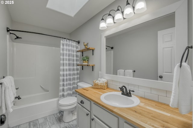 full bathroom with tasteful backsplash, toilet, shower / bath combo with shower curtain, a skylight, and vanity