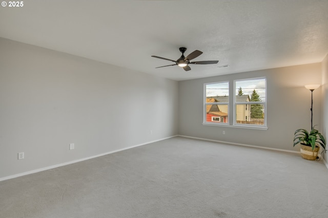 carpeted spare room with baseboards and ceiling fan