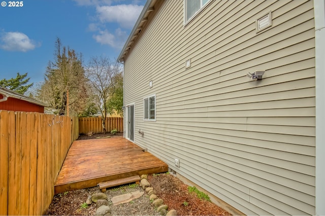 view of side of home featuring a wooden deck and fence