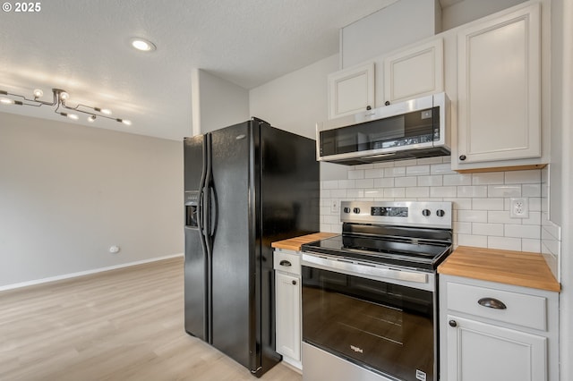 kitchen featuring tasteful backsplash, white cabinetry, butcher block counters, and stainless steel appliances