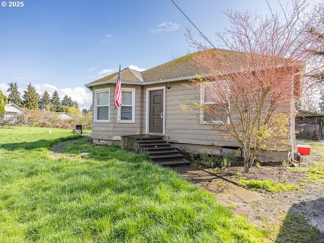 bungalow featuring a shingled roof and a front yard