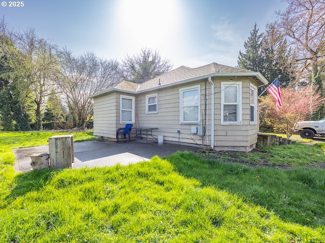 back of property featuring a patio area and roof with shingles