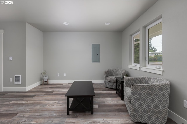 living room featuring hardwood / wood-style flooring, heating unit, and electric panel