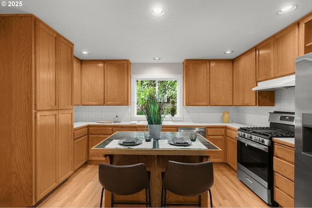 4113 SE Rural St, Portland, OR 97202 - kitchen featuring stainless steel appliances, under cabinet range hood, light countertops, light wood finished floors, and recessed lighting