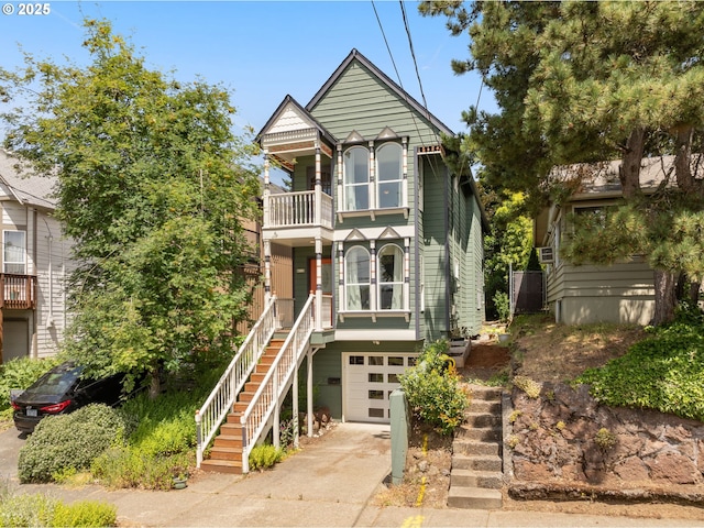 4113 SE Rural St, Portland, OR 97202 - view of front facade featuring stairs, a balcony, concrete driveway, and an attached garage