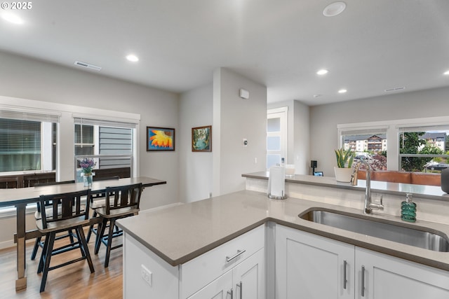 11465 SE Pleasant Valley Pkwy, Happy Valley, OR 97086 - kitchen with a sink, recessed lighting, light wood-type flooring, and white cabinets