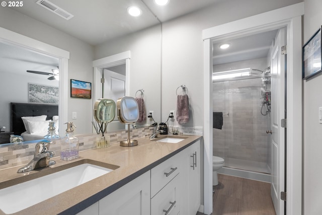 11465 SE Pleasant Valley Pkwy, Happy Valley, OR 97086 - full bathroom featuring toilet, a shower stall, double vanity, a ceiling fan, and wood finished floors