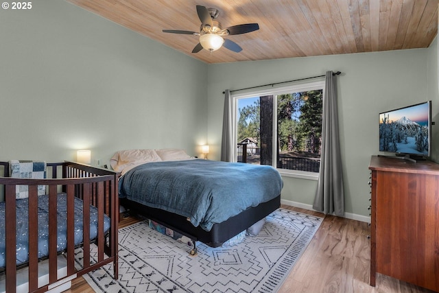 bedroom featuring vaulted ceiling, wood finished floors, wood ceiling, baseboards, and a ceiling fan
