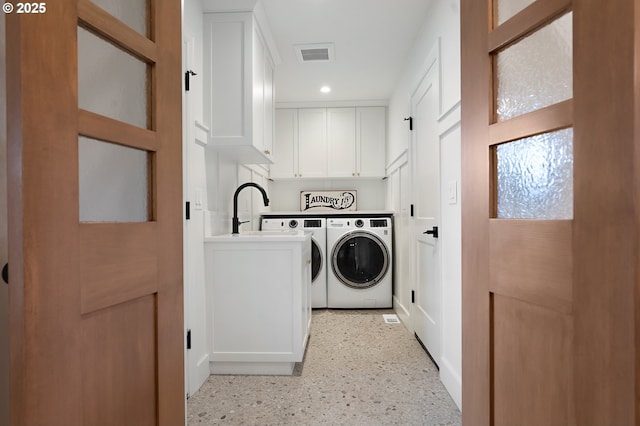 laundry area with cabinet space, separate washer and dryer, and recessed lighting