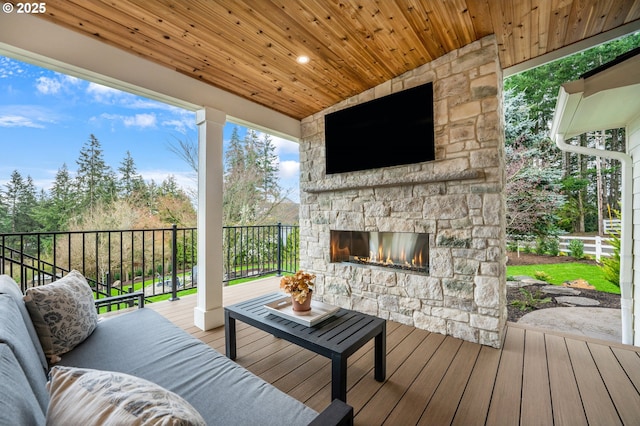 deck with an outdoor stone fireplace