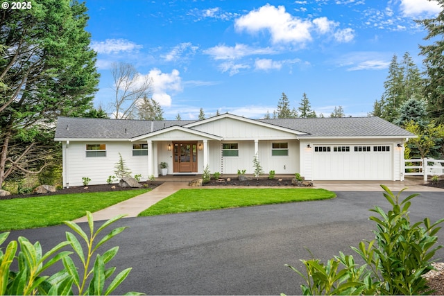 single story home with a garage, driveway, board and batten siding, and a shingled roof