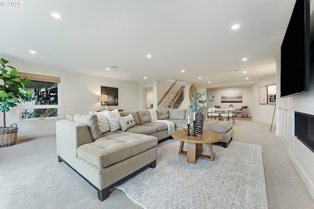 living area with light carpet, stairway, recessed lighting, and baseboards