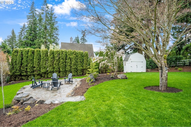 view of yard with a storage shed, a patio, an outdoor structure, and an outdoor fire pit