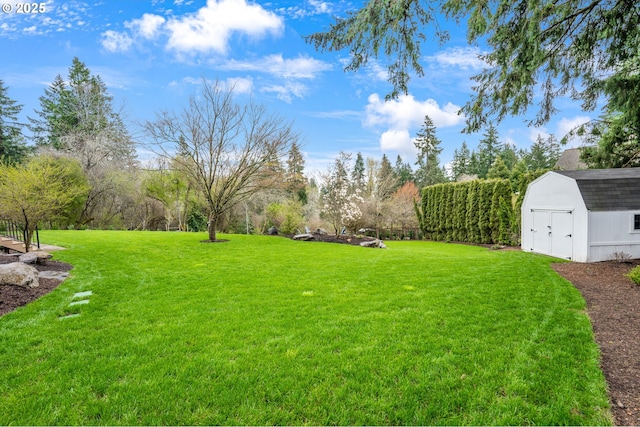 view of green lawn featuring a storage unit and an outbuilding