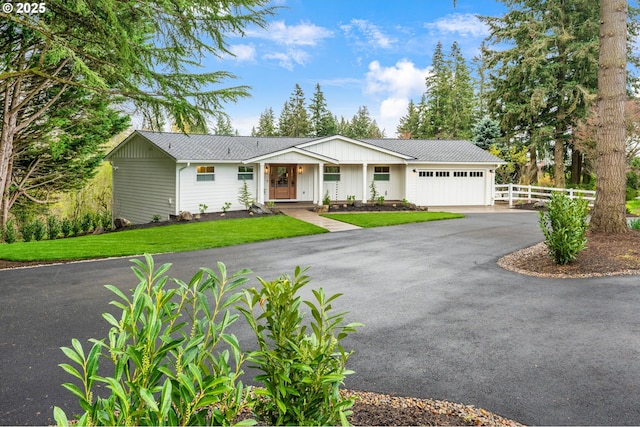 ranch-style house featuring an attached garage and asphalt driveway