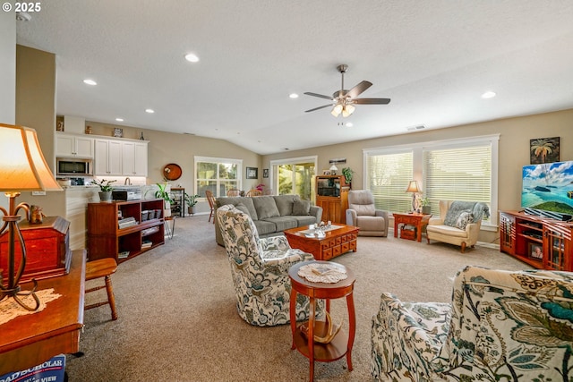 carpeted living room with lofted ceiling, ceiling fan, and a textured ceiling