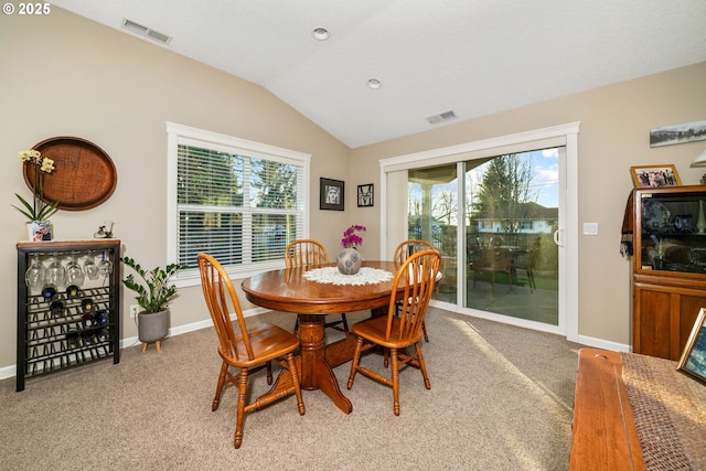 dining area with lofted ceiling and light colored carpet