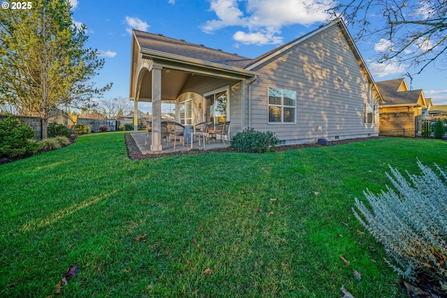 rear view of property with a lawn and a patio area