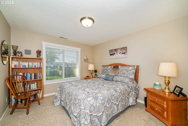 bedroom featuring light colored carpet and a textured ceiling