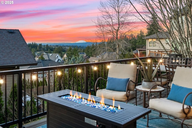 balcony at dusk featuring an outdoor fire pit and a mountain view