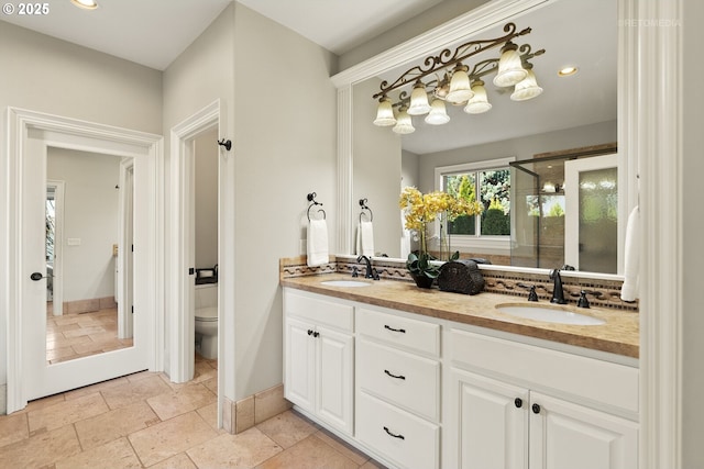 full bathroom featuring double vanity, backsplash, a sink, toilet, and stone tile floors