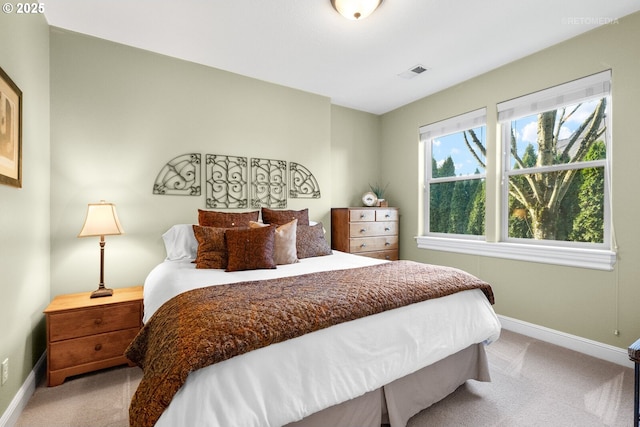 bedroom featuring baseboards, light colored carpet, and visible vents