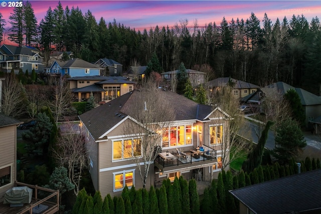 back of property at dusk featuring a residential view