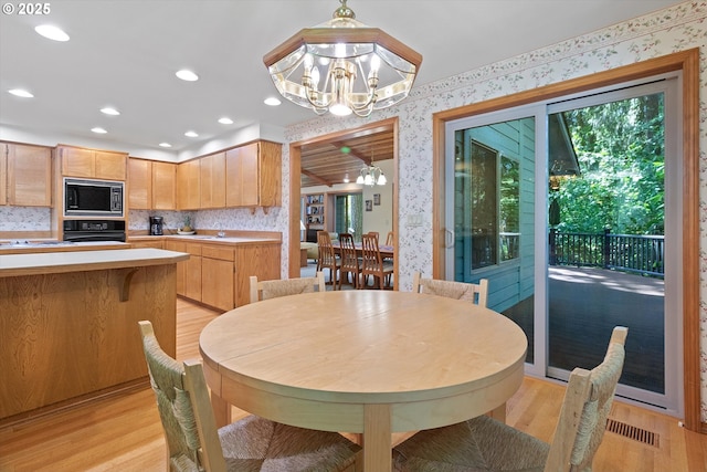 dining room featuring a chandelier, recessed lighting, light wood-style flooring, and wallpapered walls