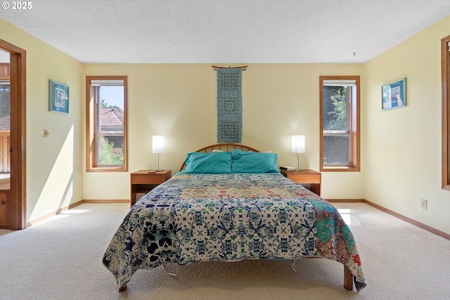 carpeted bedroom featuring multiple windows and baseboards