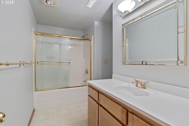 full bath with visible vents, vanity, bath / shower combo with glass door, and tile patterned floors