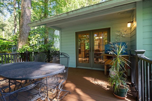 wooden terrace with outdoor dining space and french doors